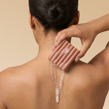 KITSCH Cleansing Amber Shores Body Wash Bar — model lathering bar on shoulder — Sudsy lather for a soft, luxurious cleanse — gentle yet effective body wash cleanses without stripping, perfect for daily use
